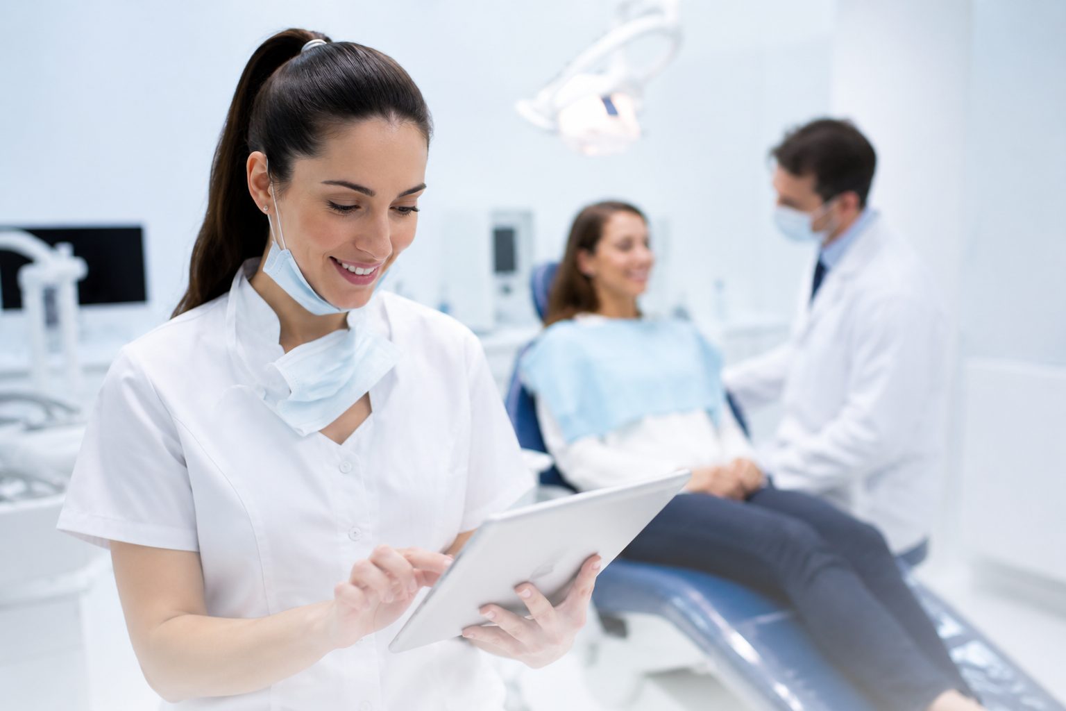 A physician reviewing notes on a tablet in a modern clinic.